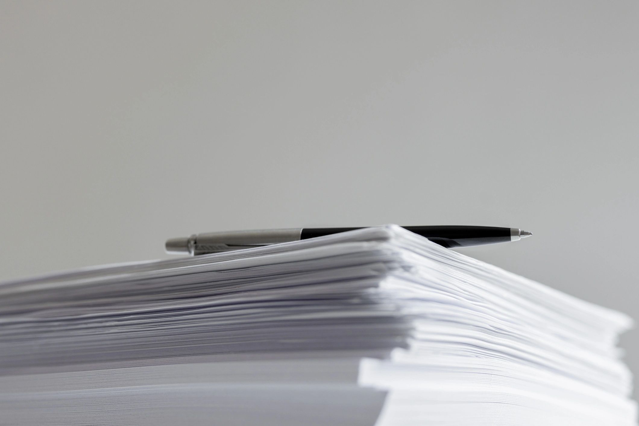 Stack of documents with a pen on top